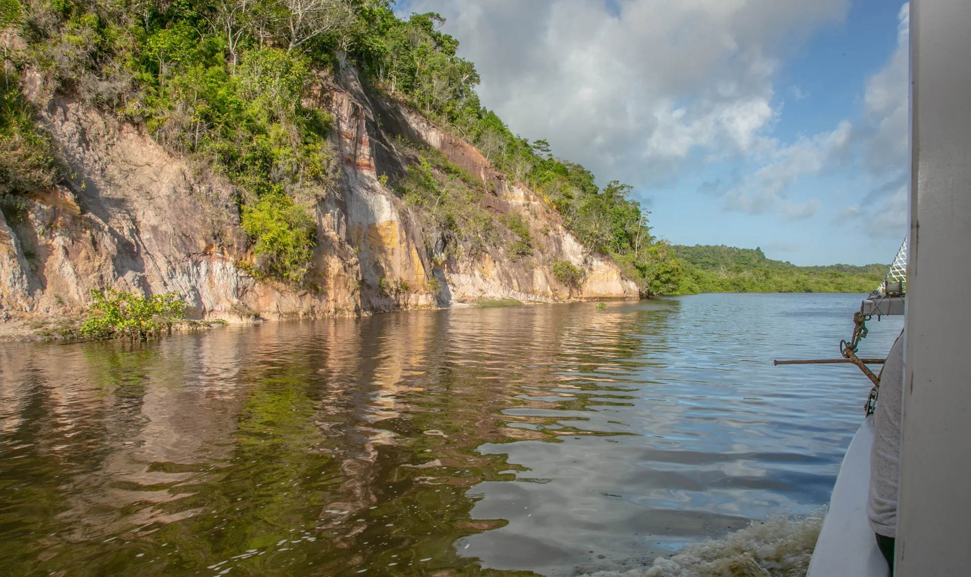 Formação rochosa e vegetação refletidas no rio