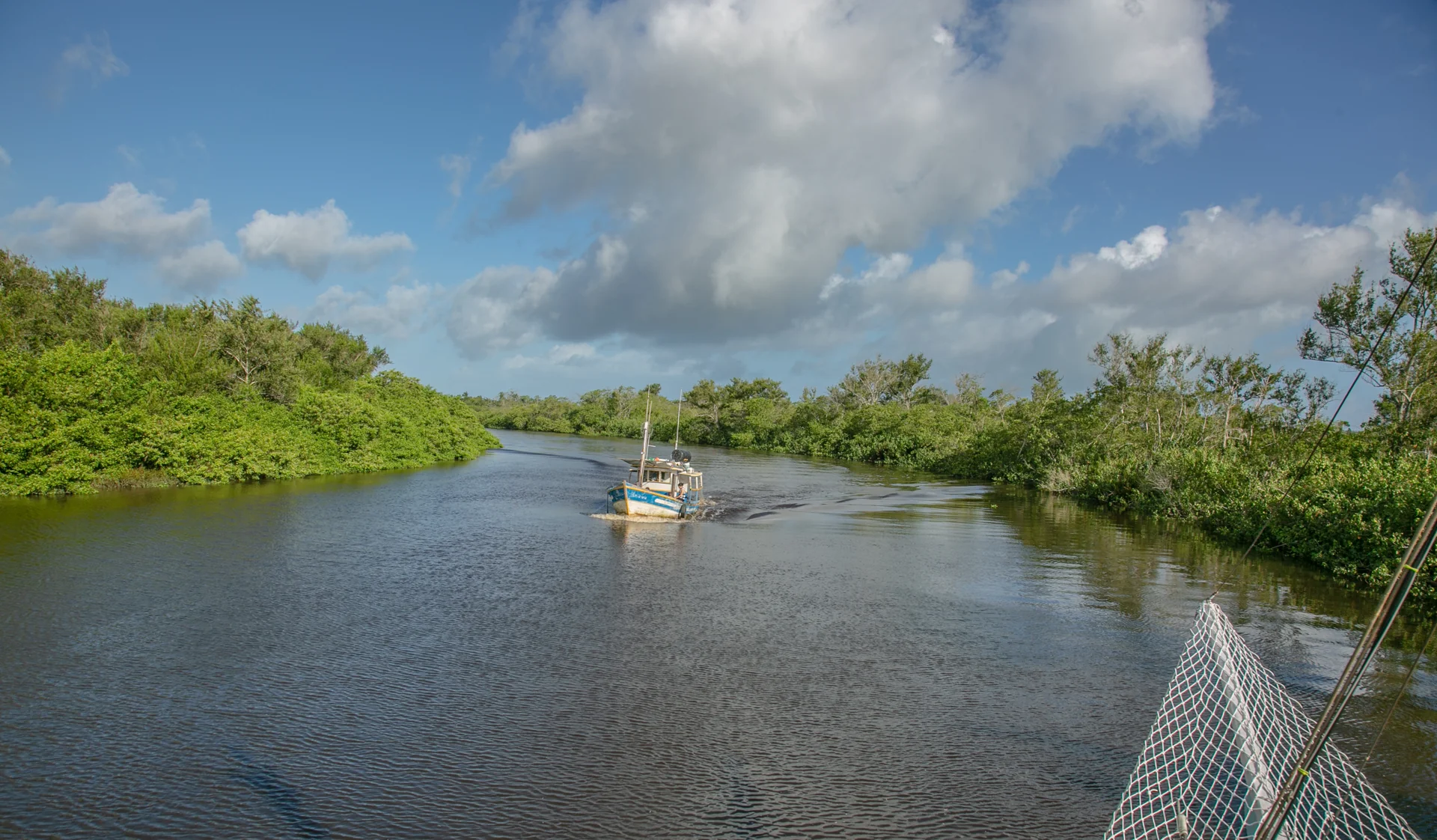 Vista do rio durante a navegação, com uma embarcação ao fundo
